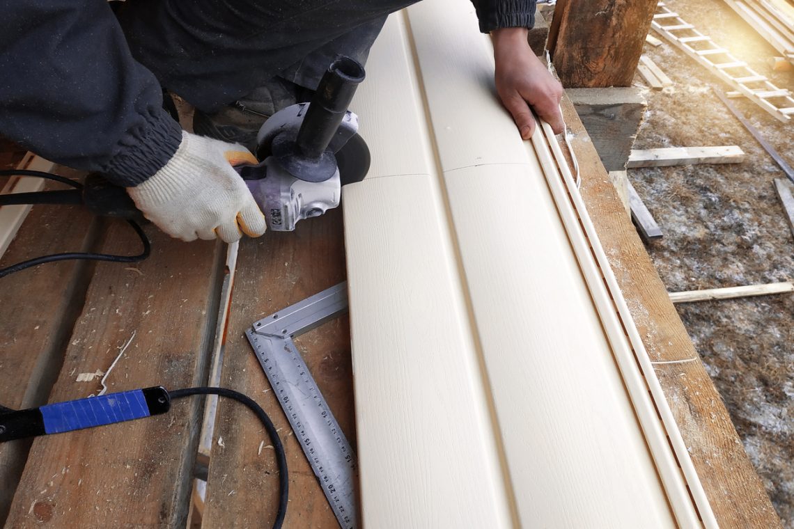 An employee cuts siding to the required size