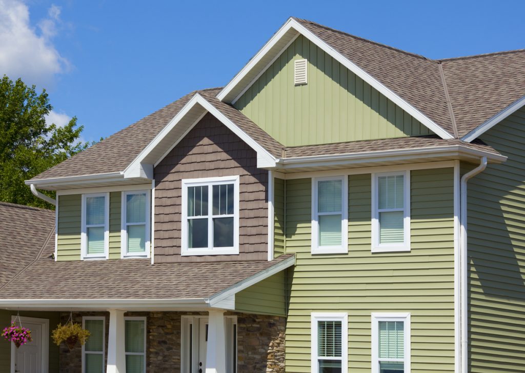 Green and Brown House of Stone, Cedar, Vinyl Siding